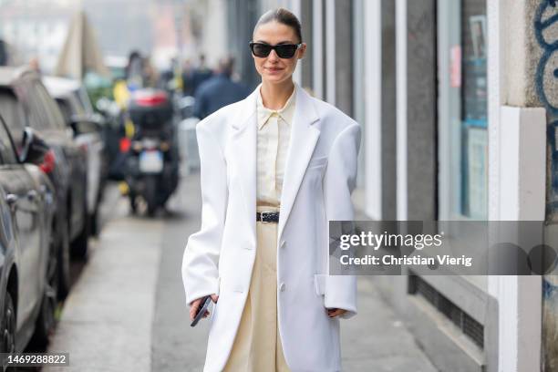 Sophia Roe wears white oversized blazer, beige wide leg pants, button shirt outside Sportmax during the Milan Fashion Week Womenswear Fall/Winter...