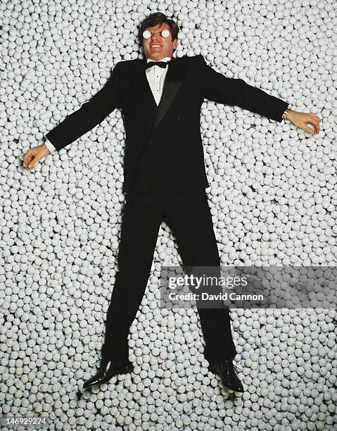 Portrait of Nick Faldo laying amongst thousands of golf balls on 1st December 1990 in London, England.