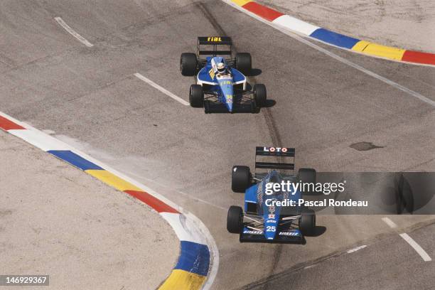 Rene Arnoux of France drives the Ligier Loto Ligier JS33 Ford Cosworth DFR ahead of Christian Danner of Germany driving the Rial Racing Rial ARC2...