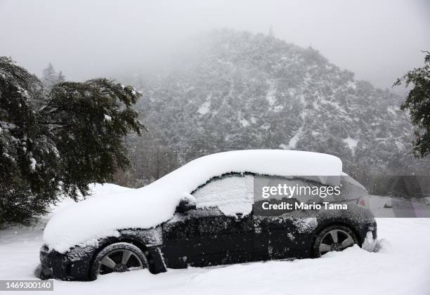 Vehicle is partially covered in snow, in the San Gabriel Mountains in San Bernardino County near Los Angeles County, on February 24, 2023 in Mount...