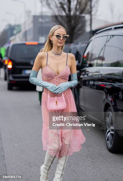 Leonie Hanne wears white blazer, pink laced transparent dress, bag, gloves, laced boots outside Gucci during the Milan Fashion Week Womenswear...