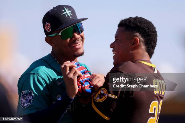 Julio Rodriguez of the Seattle Mariners and Juan Soto of the San Diego Padres greet one another during the first inning in a spring training game at...