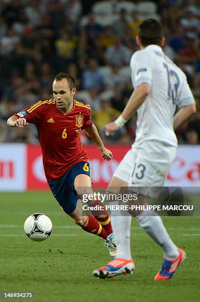 Spanish midfielder Andres Iniesta vies with French defender Anthony Reveillere during the Euro 2012 football championships quarter-final match Spain...