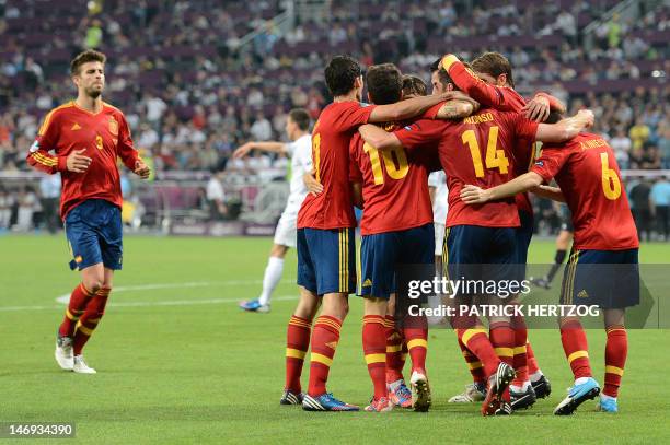 Spanish midfielder Xabi Alonso is congratulated by teammates after scoring a goal during the Euro 2012 football championships quarter-final match...