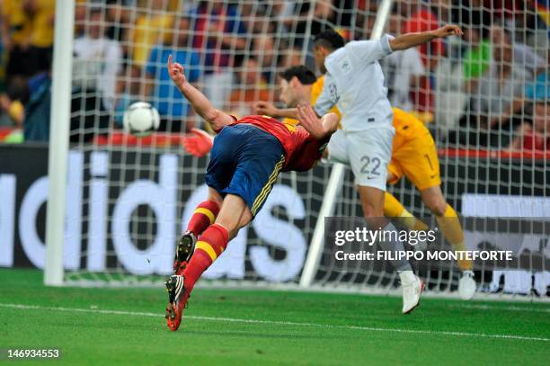 Spanish midfielder Xabi Alonso scores against French goalkeeper Hugo Lloris and French defender Gael Clichy during the Euro 2012 football...