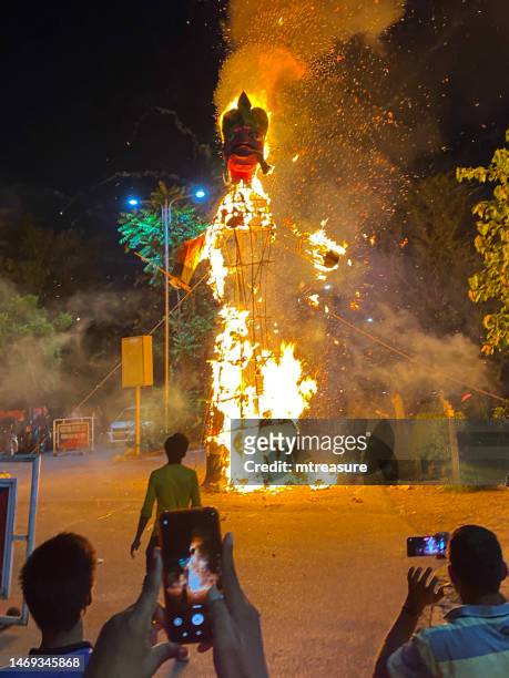 image of effigy of the demon ravana being burned as crowds of hindu people watch and film on smartphones, hindu festival of dussehra, focus on foreground - dussehra bildbanksfoton och bilder