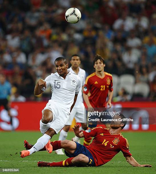 Xabi Alonso of Spain challenges Florent Malouda of France during the UEFA EURO 2012 quarter final match between Spain and France at Donbass Arena on...