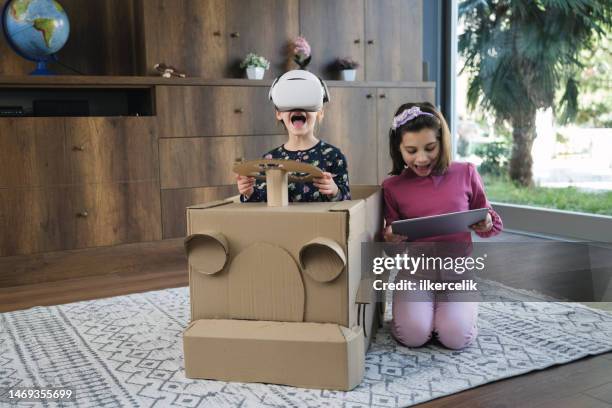 little girls having fun playing with virtual reality simulator in a car from cardboard box - cardboard vr stock pictures, royalty-free photos & images