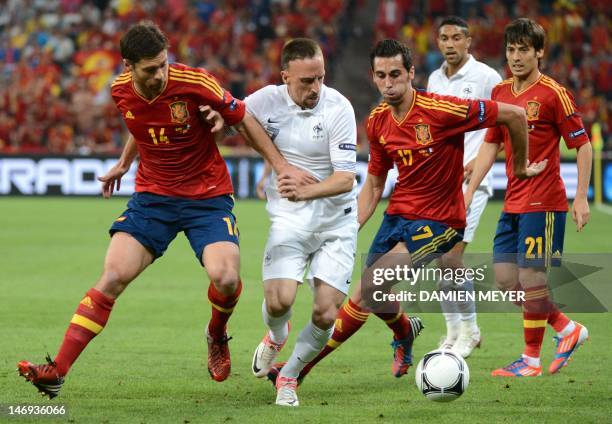 Spanish midfielder Xabi Alonso and Spanish defender Alvaro Arbeloa tackle French midfielder Franck Ribery during the Euro 2012 football championships...