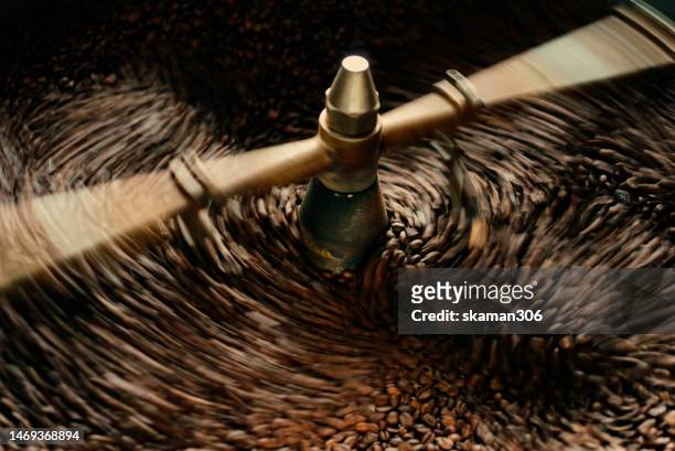 close up slow motion cooling batch spinning   roasted coffee beans with a roasting machine - coffee slow motion stock pictures, royalty-free photos & images