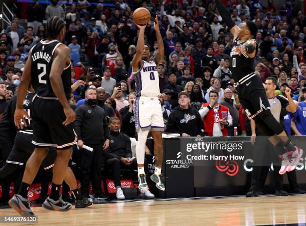 Malik Monk of the Sacramento Kings scores a three pointer between Kawhi Leonard and Russell Westbrook of the LA Clippers to send the game into...