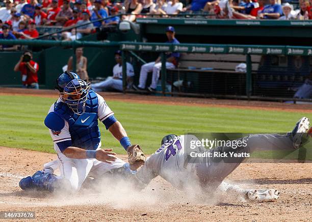 Yorvit Torrealba of the Texas Rangers tags Wil Nieves of the Colorado Rockies out at home in the interleague game at Rangers Ballpark in Arlington on...