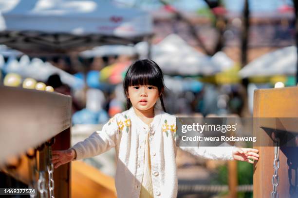 asian girl kid playing walk on balance beam at outdoor playground at the public park - playground balance beam stock pictures, royalty-free photos & images