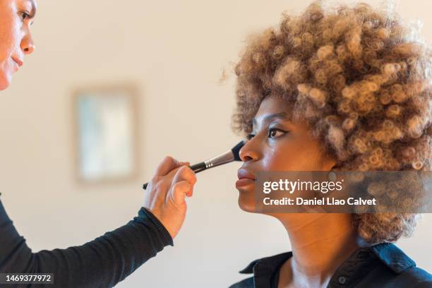 professional makeup artist applying powder with make-up brush on woman face. - make up pinsel stock-fotos und bilder