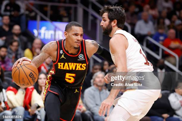 Dejounte Murray of the Atlanta Hawks dribbles against Ricky Rubio of the Cleveland Cavaliers during the second half of the game at State Farm Arena...