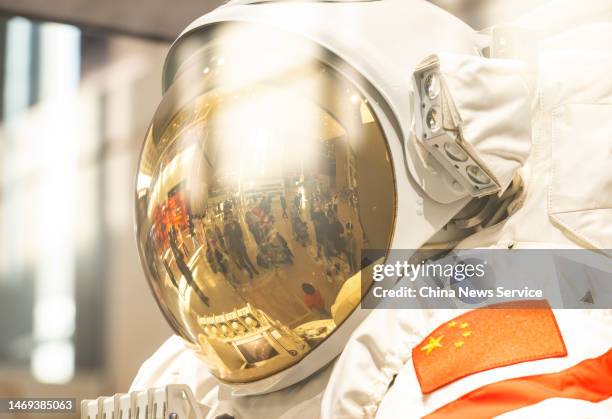 Reflection of visitors is seen in an astronaut helmet during the Exhibition of Achievements in China's Manned Spaceflight Program of 30 Years at the...