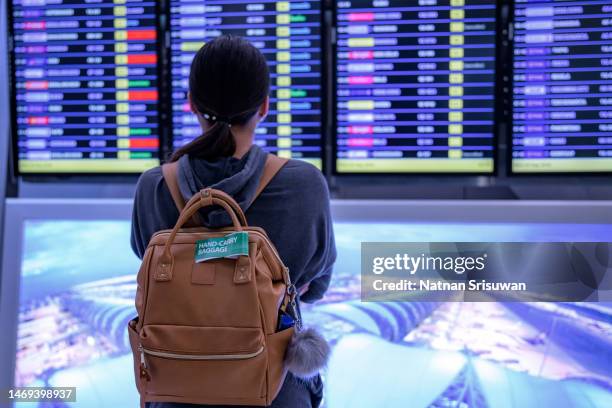 young woman at the airport in barcelona checking for the flight schedule - cancellation stock pictures, royalty-free photos & images