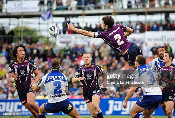 Matt Duffie of the Storm gets airborne to knock back a ball to Kevin Proctor of the Strom during the round 16 NRL match between the Canterbury...