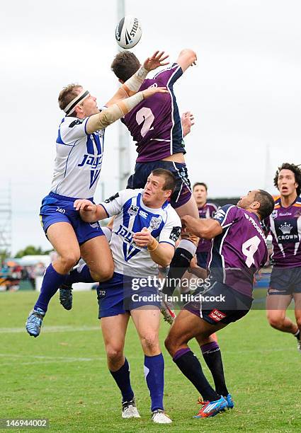 Matt Duffie and Justin O'Neill of the Storm contests a high ball with Luke MacDougall and Josh Morris of the Bulldogs during the round 16 NRL match...