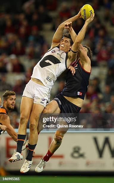 Phil Davis of the Giants marks infront of Jared Rivers of the Demons during the round 13 AFL match between the Melbourne Demons and the Greater...