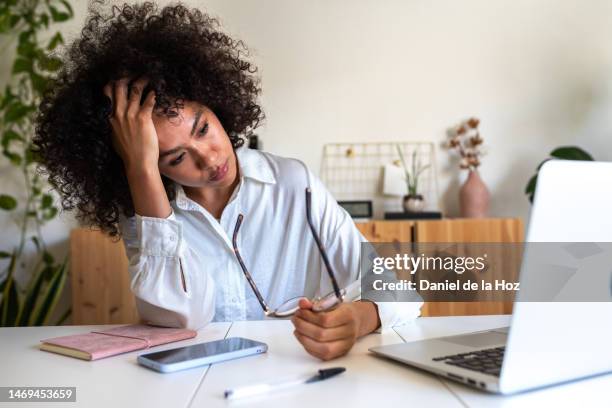 young african american woman feeling exhausted and depressed sitting in front of laptop. work burnout syndrome. - estrés fotografías e imágenes de stock