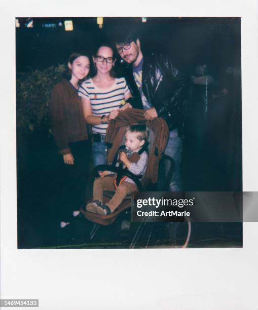 family portrait real instant photo of a married couple with two children outdoors in the evening - real people family portraits stockfoto's en -beelden