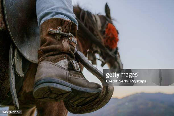 cowboy boot in stirrups. - stirrup stock pictures, royalty-free photos & images