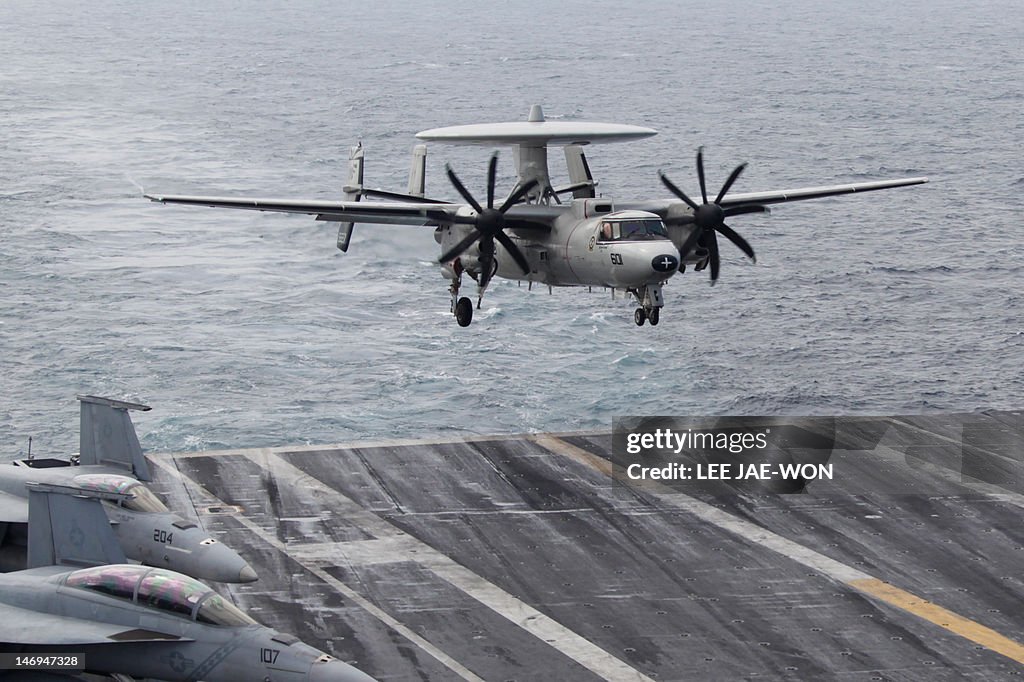 An E-2C Hawkeye lands onto the deck of t