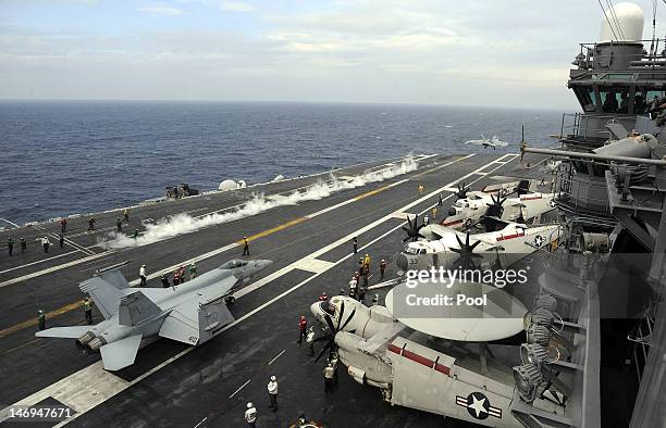 Navy crewmen work on the deck of the USS George Washington during a joint US and South Korea military exercise on the Korean Peninsula's west sea on...