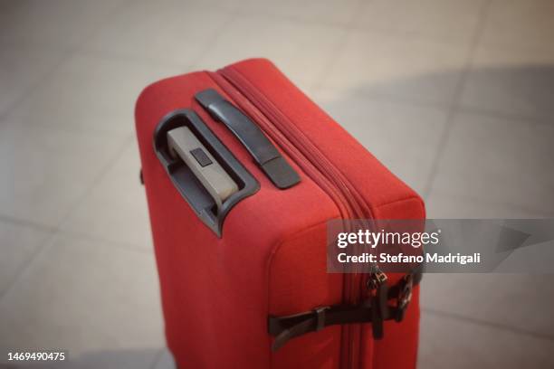 red suitcase without people - milan airport stock pictures, royalty-free photos & images