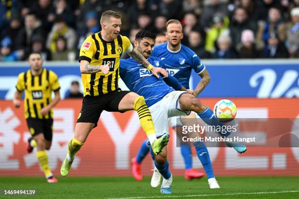 Marco Reus of Borussia Dortmund is challenged by Ozan Kabak of TSG Hoffenheim during the Bundesliga match between TSG Hoffenheim and Borussia...