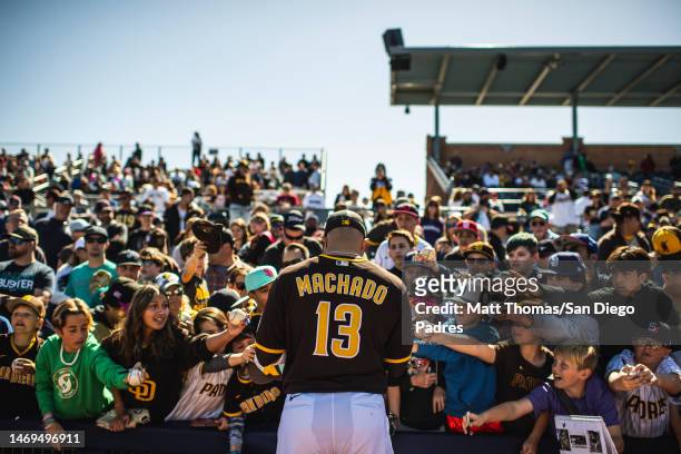 Manny Machado of the San Diego Padres signs autographs for fans before a spring training game against the Seattle Mariners at Peoria Stadium on...