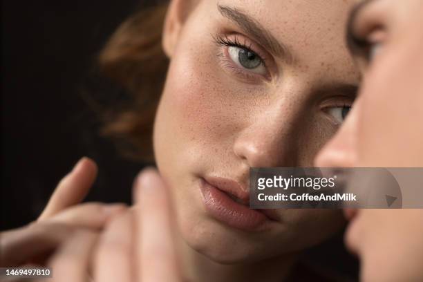 beautiful emotional woman with natural make-up looking at the mirror - adult in mirror stock pictures, royalty-free photos & images