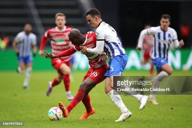 Kelvin Yeboah of FC Augsburg is challenged by Filip Uremovic of Hertha BSC during the Bundesliga match between Hertha BSC and FC Augsburg at...