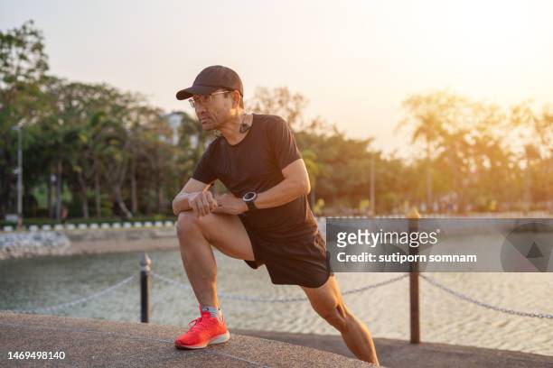 middle -aged man warm up, preparing to run and exercise. - beautiful asian legs - fotografias e filmes do acervo