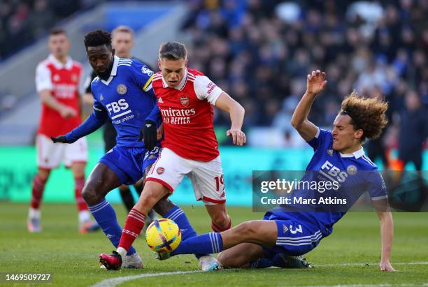 Leandro Trossard of Arsenal is challenged by Wilfred Ndidi and Wout Faes of Leicester City during the Premier League match between Leicester City and...