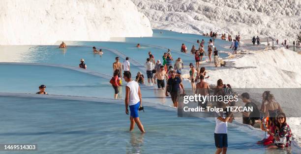 tourists visiting pamukkale tranvertines or cotton castle, turkey - pamukkale stock pictures, royalty-free photos & images