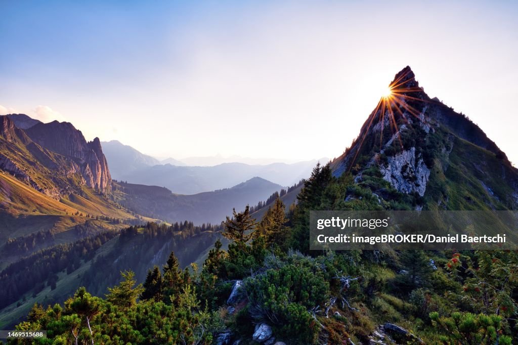 Sun star on Choepfenberg, mountain landscape at sunset, view of Glarnerland and Central Switzerland, cantons of Glarus and Schwyz, Switzerland