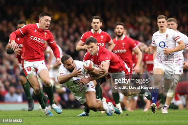 Ollie Lawrence of England is tackled by Mason Grady of Wales during the Six Nations Rugby match between Wales and England at Principality Stadium on...