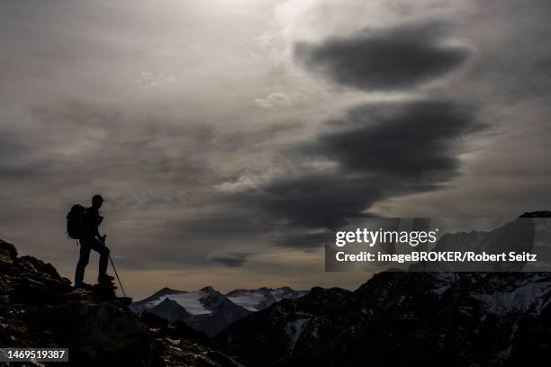 climbers on rocks in backlight with cloudy sky in the background south tyrolean mountains, martell valley, merano, vinschgau, south tyrol, italy - martell valley italy - fotografias e filmes do acervo