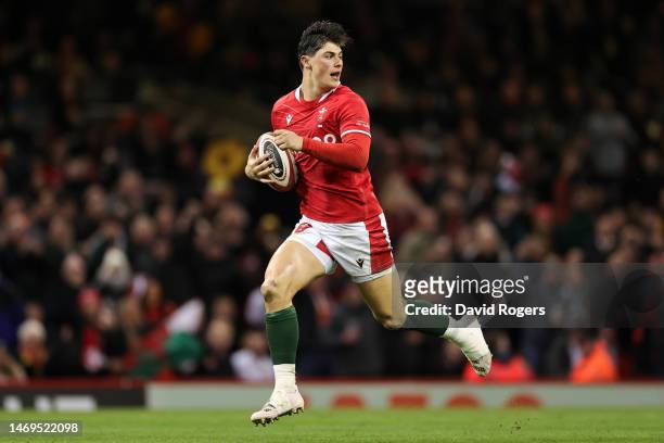 Louis Rees-Zammit of Wales breaks with the ball before scoring their side's first try of the match during the Six Nations Rugby match between Wales...