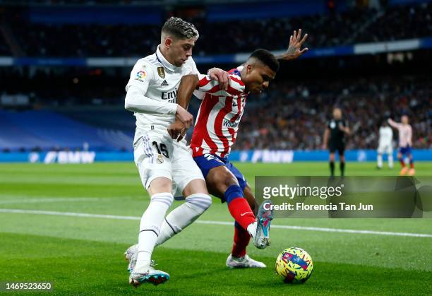 Reinildo Mandava of Atletico Madrid is challenged by Federico Valverde of Real Madrid during the LaLiga Santander match between Real Madrid CF and...