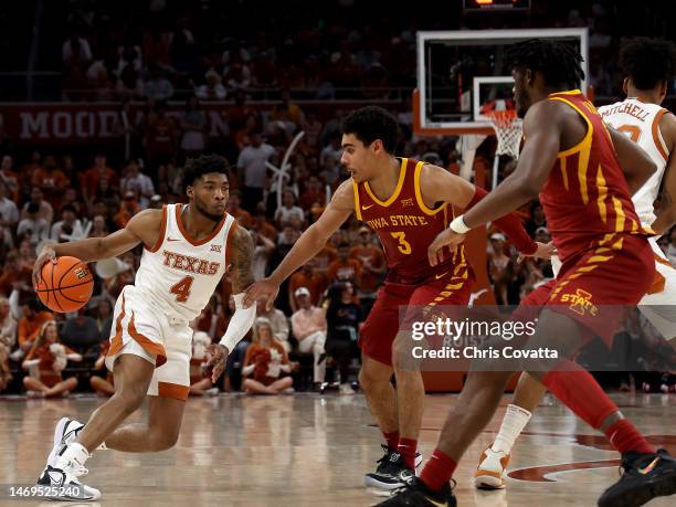 Tyrese Hunter of the Texas Longhorns moves with the ball against Tamin Lipsey and Tre King of the Iowa State Cyclones in the second half of the game...