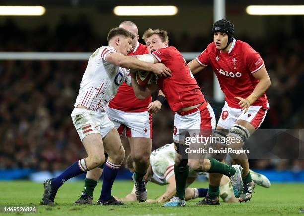 Nick Tompkins of Wales is challenged by Owen Farrell of England during the Six Nations Rugby match between Wales and England at Principality Stadium...