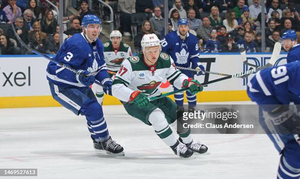 Kirill Kaprizov of the Minnesota Wild skates against Justin Holl of the Toronto Maple Leafs during an NHL game at Scotiabank Arena on February 24,...