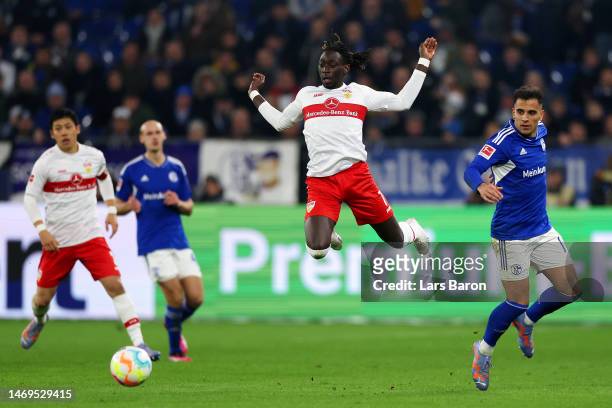 Tanguy Coulibaly of VfB Stuttgart leaps in the air after being challenged by Rodrigo Zalazar of FC Schalke 04 during the Bundesliga match between FC...
