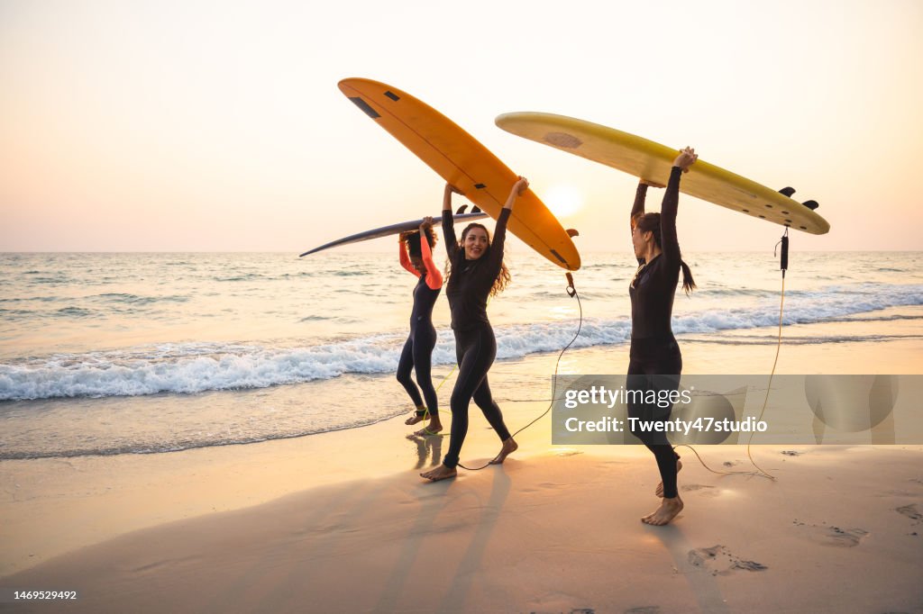 Group of female surfers walking on the beach