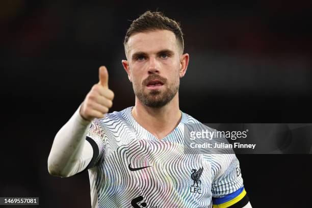 Jordan Henderson of Liverpool acknowledges the fans, whilst wearing a Captain's Armband featuring the colours of Ukraine, during the Premier League...