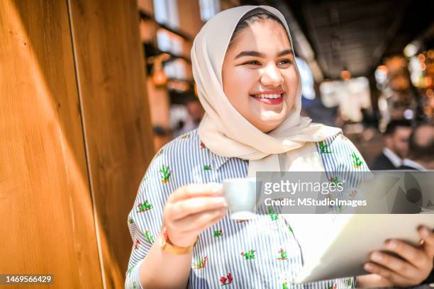 young muslim woman using digital tablet. - fat asian woman stock pictures, royalty-free photos & images