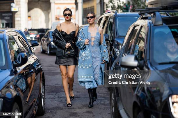 Marta Lozano wears black leather skirt top, jacket, bag & Teresa Andres Gonzalvo wears blue laced dress, coat with print outside Ermanno Scervino...